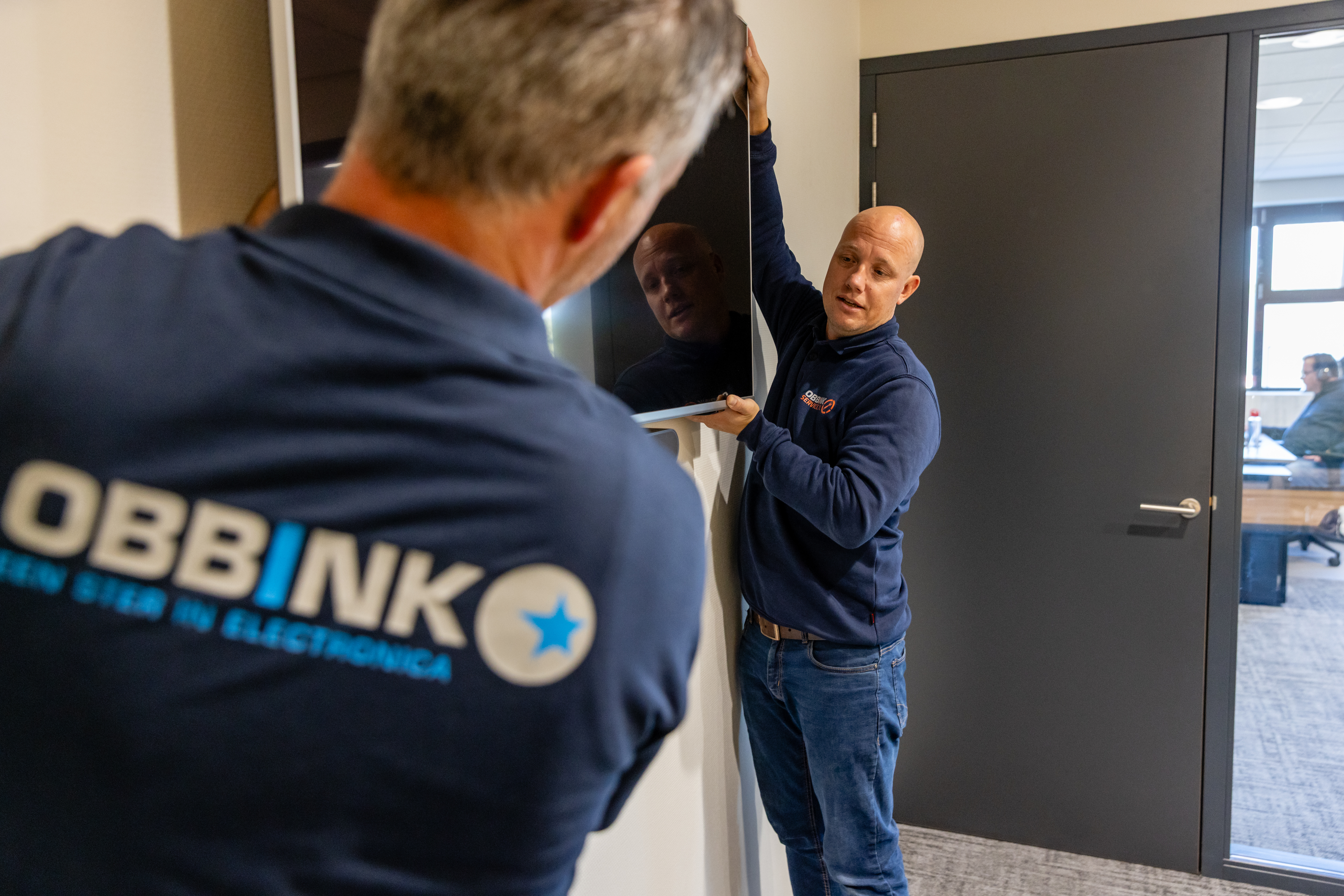 Obbink Service-medewerkers verplaatsen samen een televisie